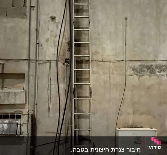 סולם מתכת צמוד לקיר עם צינורות חשמל